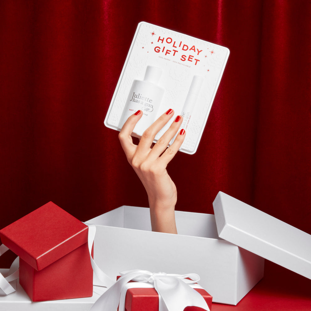 Holiday Gift Set 2023 holded by a hand out of a gift Juliette has a gun